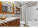 Cozy bathroom features a wood-framed mirror, sink, industrial style shelving, and a tub with shower at 326 Woodland Trl, Lady Lake, FL 32159