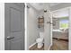 Small half-bath with toilet, floating shelves, and wood-look flooring, conveniently located near the bedroom at 326 Woodland Trl, Lady Lake, FL 32159