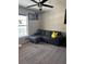 Bedroom featuring a window, ceiling fan, and a comfortable gray sectional couch with storage at 326 Woodland Trl, Lady Lake, FL 32159