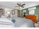 A charming bedroom features a barn door, a stylish ceiling fan, and a view into the bathroom at 326 Woodland Trl, Lady Lake, FL 32159