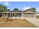 Charming single-story home with a welcoming front porch and well-maintained lawn at 326 Woodland Trl, Lady Lake, FL 32159