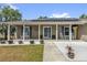 Cozy front porch with rocking chairs, decorative shutters, and potted plants at 326 Woodland Trl, Lady Lake, FL 32159