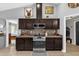 Stylish kitchen with stainless steel appliances, dark wood cabinets, and a view into the laundry room at 326 Woodland Trl, Lady Lake, FL 32159