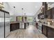 A contemporary kitchen showcases stainless steel appliances, dark cabinets, and opens to the dining area at 326 Woodland Trl, Lady Lake, FL 32159