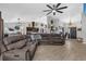 Open concept living area with a large sectional, view of the kitchen, and modern decor at 326 Woodland Trl, Lady Lake, FL 32159