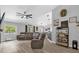 Spacious living room featuring a large sofa, modern fan, and plenty of natural light at 326 Woodland Trl, Lady Lake, FL 32159