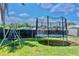 Spacious backyard featuring a trampoline, see-saw and a secure fence for outdoor fun and privacy at 3328 Fox Ridge, Winter Haven, FL 33884