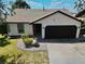 Charming single-story home with a well-manicured lawn and a black two-car garage at 3328 Fox Ridge, Winter Haven, FL 33884