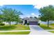 Inviting single-story home featuring a green lawn, mature trees, and a convenient two-car garage at 337 Giovani Blvd, Clermont, FL 34715