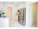 Bright kitchen featuring white cabinetry, gold hardware, stainless steel appliances and white marble flooring at 337 Giovani Blvd, Clermont, FL 34715