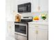 Modern kitchen with stainless steel oven and black microwave over the stove and white cabinetry at 337 Giovani Blvd, Clermont, FL 34715