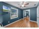 Cozy bedroom with wood floors, ceiling fan, and ample natural light from the window at 3601 Midiron Dr, Winter Park, FL 32789