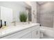 Bathroom featuring double vanity with white cabinets, granite countertop and tiled shower-tub at 3777 Sw 130Th Loop, Ocala, FL 34473