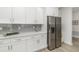 Modern kitchen with stainless steel appliances, white cabinets, and gray subway tile backsplash at 3777 Sw 130Th Loop, Ocala, FL 34473