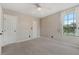 Bright bedroom with neutral walls, carpeted floors, and a large window overlooking the tennis court at 390 Lake Placid Ct # 304, Altamonte Springs, FL 32701