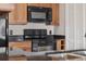 Kitchen featuring wooden cabinets, black appliances and complementing granite countertops at 390 Lake Placid Ct # 304, Altamonte Springs, FL 32701