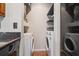 Laundry room with white, front-load washer and dryer under wooden shelves at 390 Lake Placid Ct # 304, Altamonte Springs, FL 32701