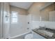 Bathroom featuring a shower-tub combo, tiled walls, granite vanity top, and natural lighting from the window at 4124 Caywood Cir, Orlando, FL 32810