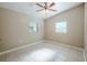 This bedroom features tile flooring, a ceiling fan, and two windows for natural light at 4124 Caywood Cir, Orlando, FL 32810