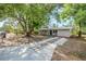 Single-story home featuring a neutral color, a long driveway, and a mature tree in the front yard at 4124 Caywood Cir, Orlando, FL 32810