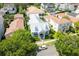 An aerial view of a light grey home highlighting a backyard pool, manicured lawn and neighborhood at 4148 Oak St, Orlando, FL 32814