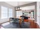 Dining area with a modern light fixture, wooden table with seating for four, and open access to the living room at 4148 Oak St, Orlando, FL 32814