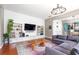 The light filled living room features a large tv, shelving, and a modern couch, flowing into the dining and kitchen at 4148 Oak St, Orlando, FL 32814