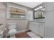 Bright bathroom features a window, toilet, vanity with granite countertop, and wood-look flooring at 424 Eden Park Rd, Altamonte Springs, FL 32714