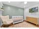 The Bedroom features a white crib, rocking chair, area rug and green accent wall at 424 Eden Park Rd, Altamonte Springs, FL 32714