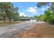 This home has a covered porch, a two car garage, and a long, gravel driveway at 424 Eden Park Rd, Altamonte Springs, FL 32714