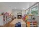 Bright playroom featuring a cozy fireplace, hardwood floors, and organized storage shelves at 424 Eden Park Rd, Altamonte Springs, FL 32714