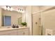 Well-lit bathroom with double sinks, white cabinets, and a glass-enclosed shower at 4557 Ranunculus St, Haines City, FL 33844