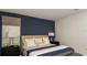 Cozy bedroom with a blue accent wall, comfortable bed, and stylish nightstands with lamps at 4557 Ranunculus St, Haines City, FL 33844