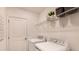 Bright laundry room featuring white washer and dryer, with storage shelf and laundry-themed wall art at 4557 Ranunculus St, Haines City, FL 33844