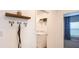 Laundry room entrance featuring washer, storage shelves, dog leash hooks, and a jar of dog treats at 4557 Ranunculus St, Haines City, FL 33844
