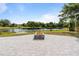 Enjoy this backyard's fire pit with brick surround and panoramic view of the lake at 51 Spruce Ln, Debary, FL 32713