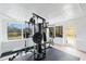 Bright exercise room features a multi-station weight machine, views of the water, and light wood flooring at 51 Spruce Ln, Debary, FL 32713