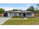 Charming, single-story home featuring a well-manicured lawn, solar panels and a freshly paved driveway at 51 Spruce Ln, Debary, FL 32713