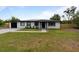 Charming home with well-manicured lawn, gray driveway, and solar panels at 51 Spruce Ln, Debary, FL 32713