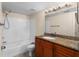 This bathroom features a tiled shower and tub combo and dark cabinets under a granite countertop at 5112 Conroy Rd # 13, Orlando, FL 32811