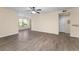 Bright living room with wood-look flooring, ceiling fan, and natural light through a large window at 5112 Conroy Rd # 13, Orlando, FL 32811