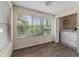 Sunny sunroom/den with wood-look floors, a large window overlooking lush greenery, and laundry closet at 5112 Conroy Rd # 13, Orlando, FL 32811