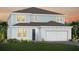 Charming two-story home with blue siding, a gray roof, a two-car garage and beautifully landscaped front yard at 5262 Foothills Preserve Loop, Mount Dora, FL 32757