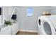 Laundry room featuring white cabinetry, shelving, and modern washer and dryer at 5262 Foothills Preserve Loop, Mount Dora, FL 32757