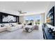 Modern living room with a large white sectional, big windows, and custom accent wall at 5262 Foothills Preserve Loop, Mount Dora, FL 32757