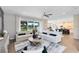 Sunlit living room featuring plush sofas, a stylish rug, and open access to the dining and kitchen areas, promoting seamless living at 5262 Foothills Preserve Loop, Mount Dora, FL 32757