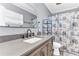 Bathroom featuring a large vanity, modern faucet, and a shower with a decorative floral curtain at 5904 Lakewood Ln, Lakeland, FL 33805