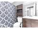 Well-organized bathroom includes toilet, dark wood vanity with sink, and a patterned shower curtain at 5904 Lakewood Ln, Lakeland, FL 33805
