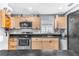 Updated kitchen showcasing stainless steel appliances, light wood cabinets, and black countertops at 5904 Lakewood Ln, Lakeland, FL 33805