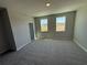 Spacious bedroom showcasing neutral walls and carpet, with two large, bright windows at 652 Pothos St, Apopka, FL 32703